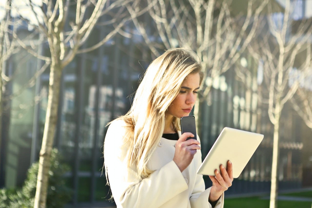 brown-haired-woman-holding-a-white-wireless-device-789703