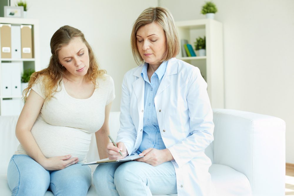 pregnant-woman-talking-her-doctor-room-1
