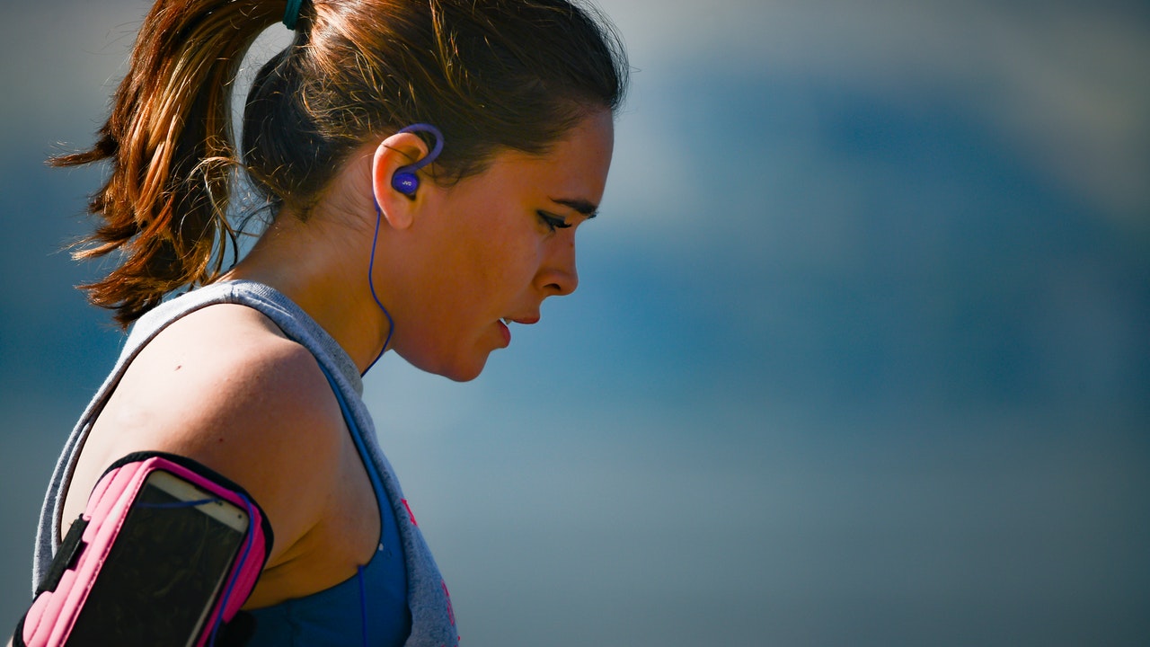 woman-wearing-smartphone-armband-and-blue-earphones-2291874